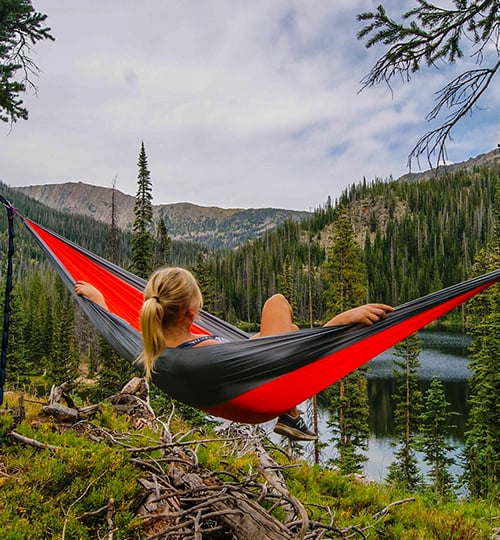 Girl relaxing in a hammock overlooking trees